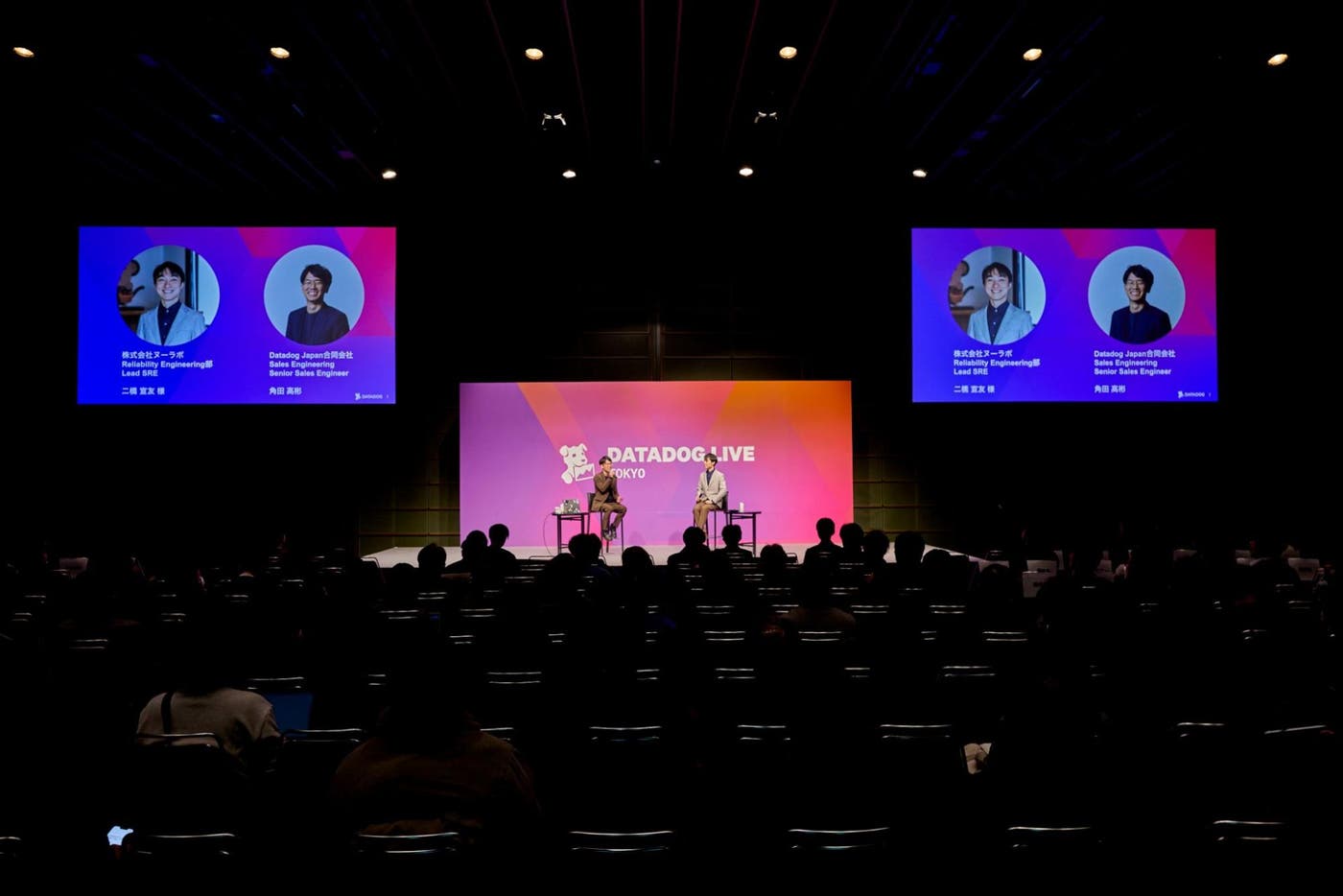Datadog Live Tokyo 2025 のステージで、観客の前に登壇者が着席し対談を行っている様子。 Datadog Live Tokyo 2025 のステージで、観客の前に登壇者が着席し対談を行っている様子。